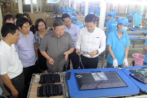 Ông chủ 8X Phạm Văn Tam (áo trắng bìa phải) đang giới thiệu quy trình sản xuất tivi 