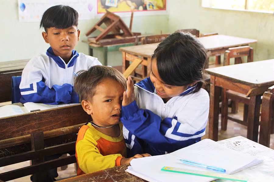 Trang dỗ dành em khi cậu bé khóc vì thấy người lạ. Ảnh: Nguyễn Giang