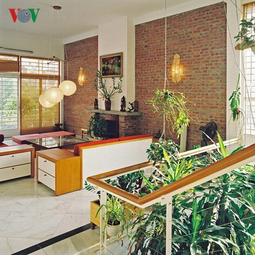 Góc nhìn từ cầu thang về phòng sinh hoạt chung. Phong cách nội thất khá đơn giản, kết hợp của hai yếu tố thô mộc và thanh lịch được thể hiện qua những mảng gạch trần và sắc trắng của tường.