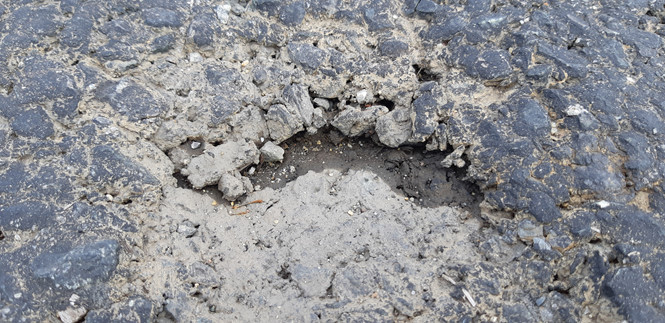 Mặt đường trên cầu VD09B đã xảy ra bong tróc ẢNH: HIỂN CỪ