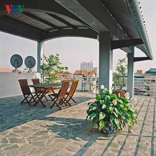  Sân thượng mái tôn nhưng không hề xấu, trái lại rất ấn tượng với những dầm bê tông cong, hệ xà gồ và công son thép.