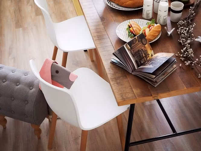 Bàn gỗ thô tạo nên sự liên kết đặc biệt với nội thất màu sáng xung quanh.