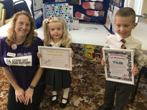 Tyler và em gái đều bị tự kỷ. Nhân viên Hiệp hội tự kỷ quốc gia trao bằng khen cho hai anh em. Ảnh: Metro.