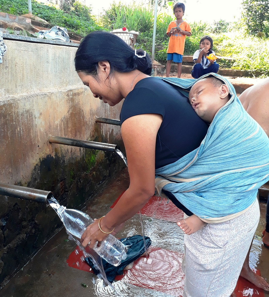 Các bà, các mẹ thường địu con ra giặt giũ, hứng nước. Ảnh: Trần Dung