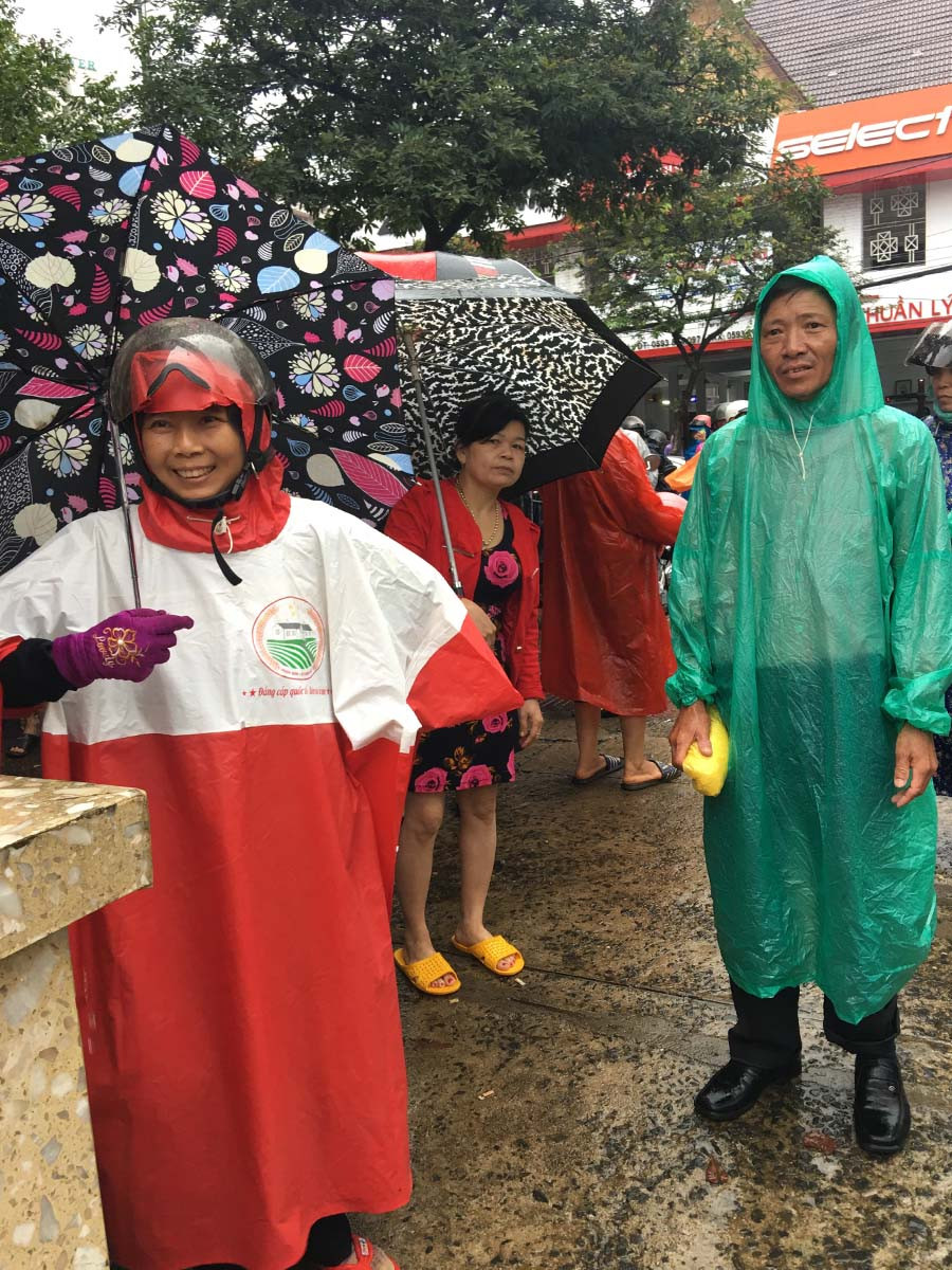  Áo mưa sẵn sàng trên tay đợi con hoàn thành bài thi. Ảnh: Hoàng Ngọc