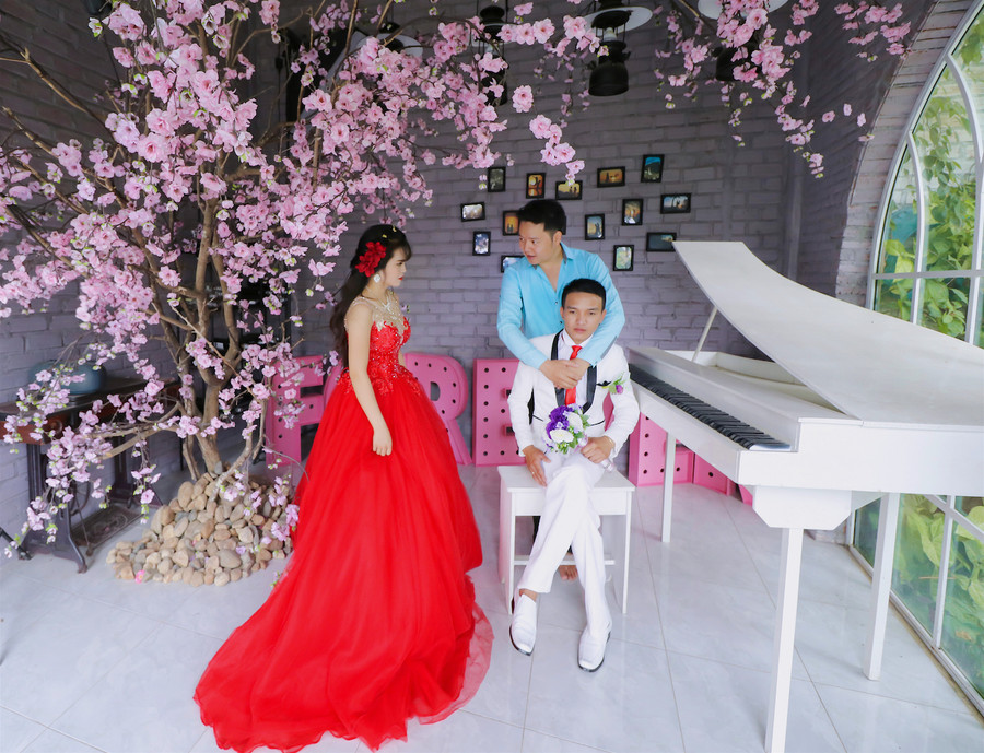 Anh Phong (áo xanh) hướng dẫn cô dâu-chú rể cách tạo dáng để có những bức hình đẹp ngay tại phim trường của mình. Ảnh: Hồng Thi Anh Phong hướng dẫn các cặp đôi cách tạo dáng để có những bức hình đẹp ngay tại phim trường của mình. Ảnh: Hồng Thi