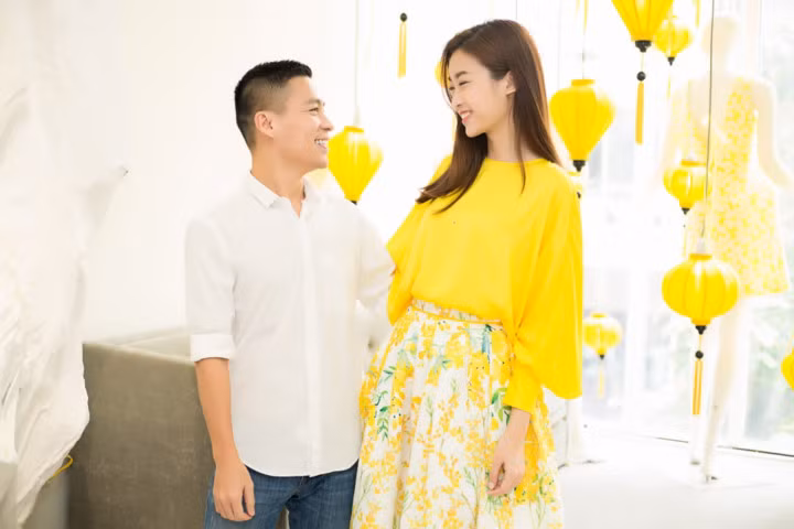 Bộ cánh thứ hai kết hợp giữa chiếc áo đơn sắc với chân váy xoè hoạ tiết hoa nữ tính.