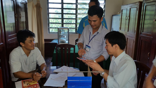 Thầy Cường (giữa) đang hướng dẫn các giáo viên tại Trường THPT Phú Hữu sử dụng smartphone chấm bài thi