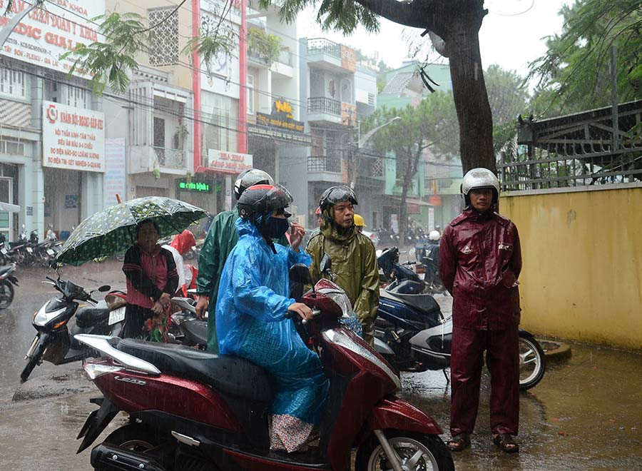 Kết thúc buổi thi cuối cùng, trời Pleiku xuất hiện cơn mưa tầm tã, nhiều bậc phụ huynh sẵn sàng đội mưa, túc trực trước cổng trường thi đợi con. Ảnh: Phương Vi