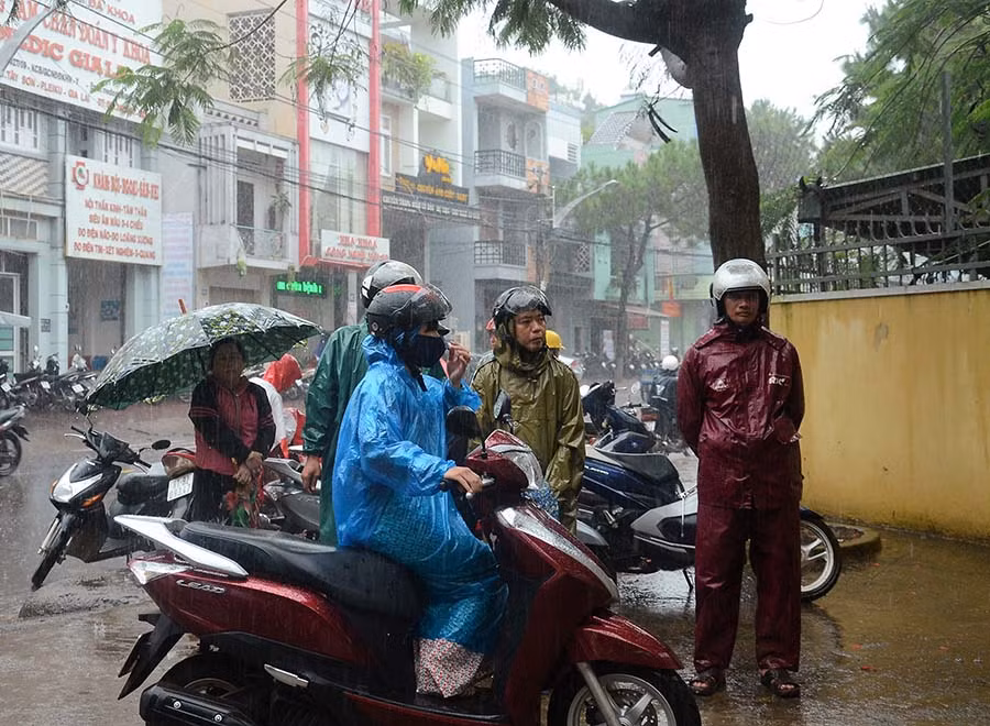 Kết thúc buổi thi cuối cùng, trời Pleiku xuất hiện cơn mưa tầm tã, nhiều bậc phụ huynh sẵn sàng đội mưa, túc trực trước cổng trường thi đợi con. Ảnh: Phương Vi