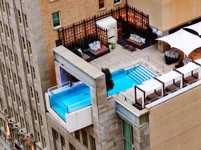 Không phải tất cả bể bơi vô cực đều nằm ở một vùng nhiệt đới xa xôi. Điểm bắt mắt của bể bơi khách sạn Joule là nằm trên tầng thượng, ghế nằm và quầy bar có mái che, bể hướng xuống thành phố Dallas, Mỹ, nhộn nhịp bên dưới.