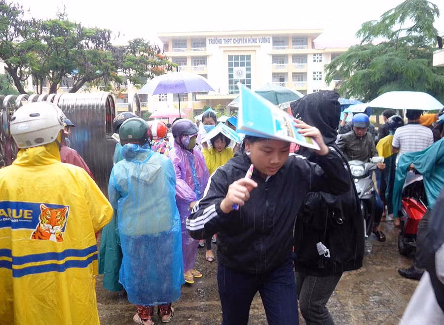 Thí sinh vội vã ra về giữa cơn mưa như trút nước trong ngày thi cuối. Ảnh: Hoàng Ngọc