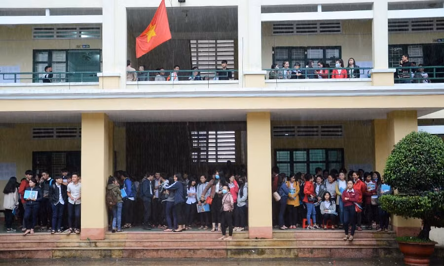 Trời bất ngờ đổ mưa lớn sau khi kết thúc môn thi cuối cùng khiến các thí sinh mắc kẹt trong trường thi. Ảnh: Phương Vi