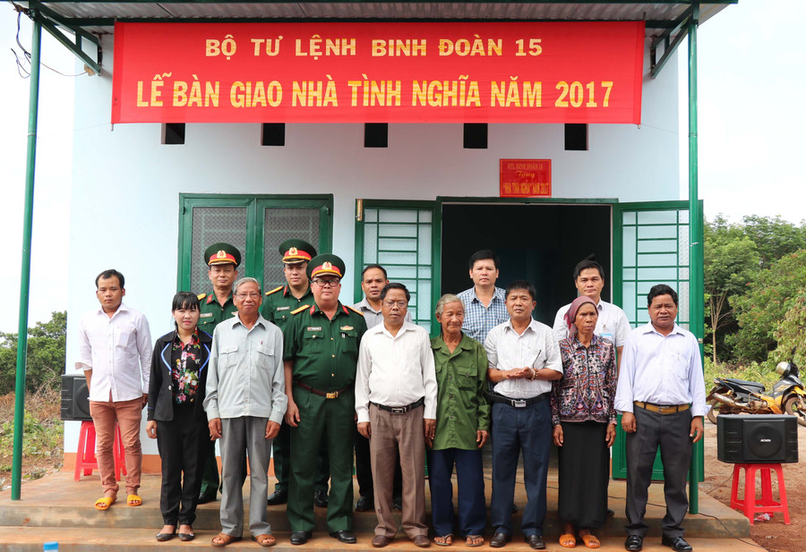 Các đại biểu chụp ảnh lưu niệm cùng các gia đình chính sách được tặng 