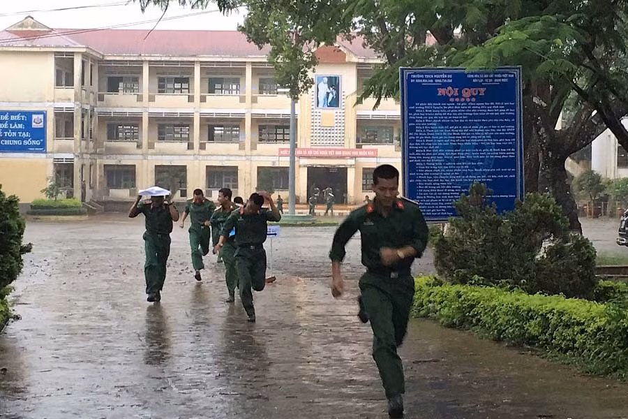 Thí sinh tự do vội vã ra về dưới trời mưa sau khi hoàn thành kỳ thi. Ảnh: Hà Duy