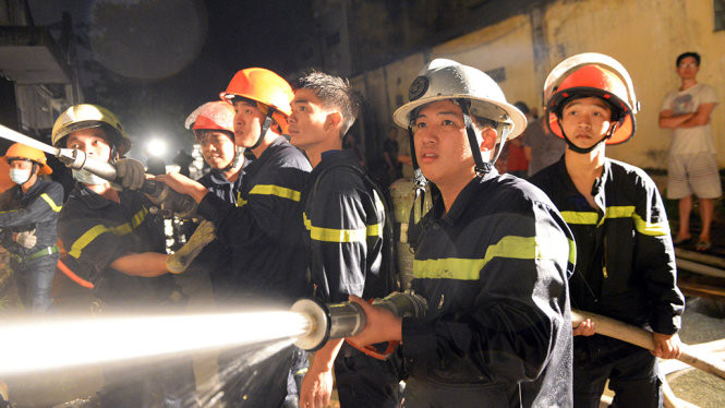 Nam (đội mũ màu trắng) cùng đồng đội phun nước dập tắt đám cháy