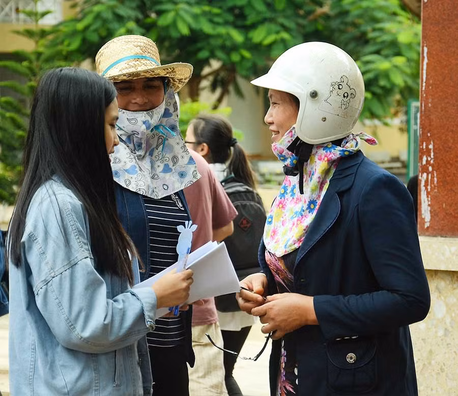 Phụ huynh ân cần, lo lắng hỏi han các thí sinh sau khi môn thi đầu tiên kết thúc. Ảnh: Phương Vi