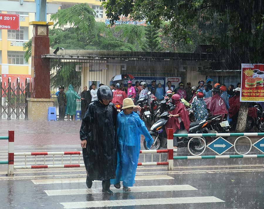 Bất chấp trời mưa, các bậc phụ huynh luôn sát cánh cùng các thí sinh. Ảnh: Phương Vi