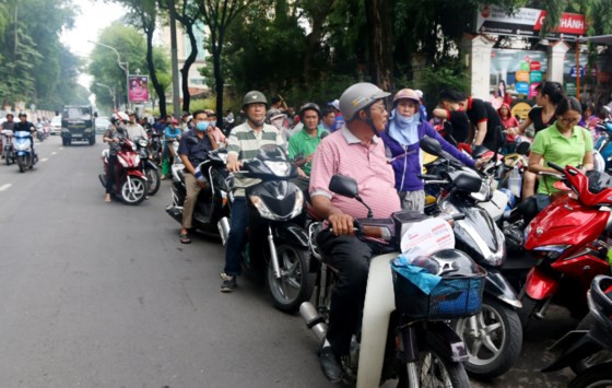 Hàng dài phụ huynh túc trực ngoài cổng trường, đứng lấn ra cả đường Nguyễn Thị Minh Khai để đợi con.