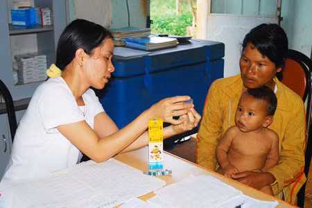 Chị Khơk được cán bộ hướng dẫn sử dụng thuốc tại Trạm Y tế xã Al Bá (Chư Sê). Ảnh: Nguyễn Giác