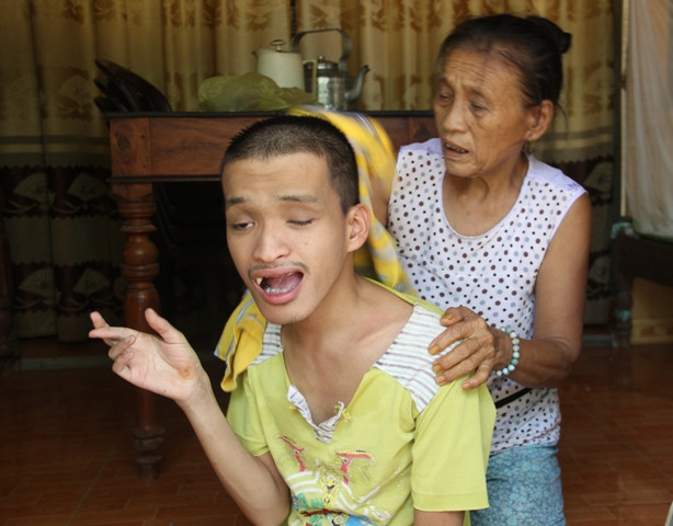 Bà Lê Thị Mít chăm sóc cho đứa con trai bị tàn tật.