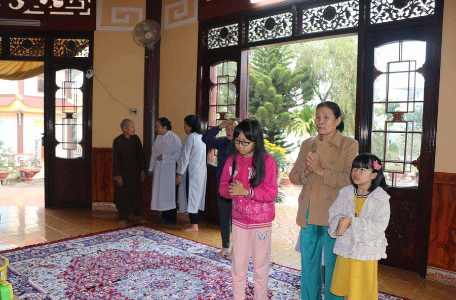 Bà Nga dắt hai cháu đi lễ chùa. Ảnh: Ngọc Minh