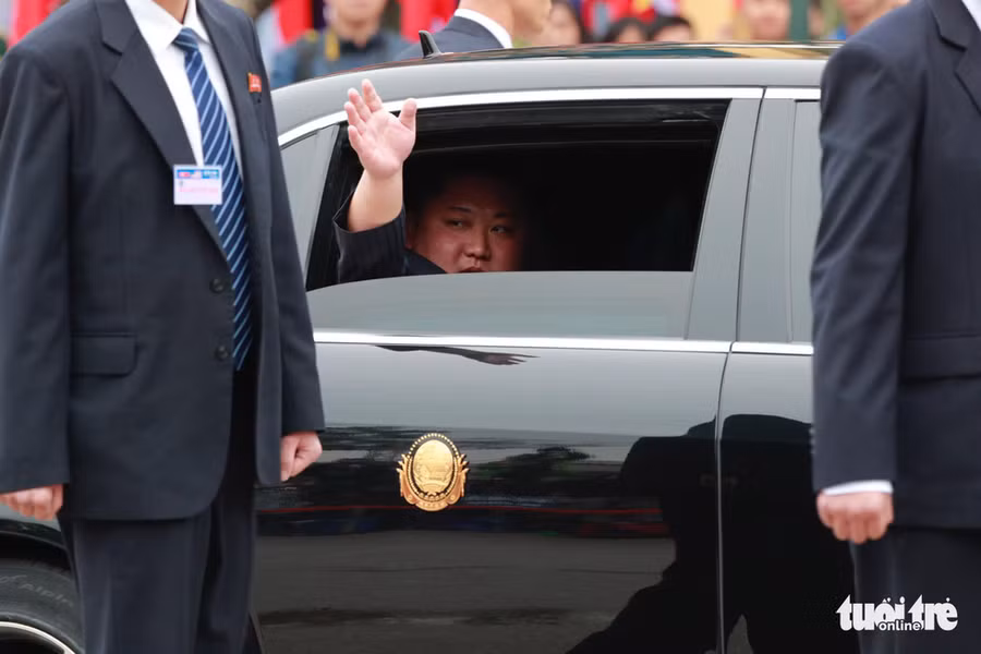  Chủ tịch Triều Tiên Kim Jong Un vẫy tay chào người dân từ trong xe - Ảnh: VIỆT DŨNG
