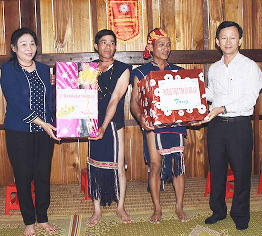 Bí thư Tỉnh ủy Dương Văn Trang và Phó Chủ tịch UBND tỉnh Huỳnh Nữ Thu Hà tặng quà cho tập thể làng Groi (xã Ya Hội, huyện Đak Pơ). Ảnh: M.T