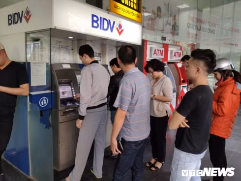 Nhiều người xếp hàng chờ đến lượt rút tiền trước Tết Nguyên đán. Nhiều người xếp hàng chờ đến lượt rút tiền trước Tết Nguyên đán.