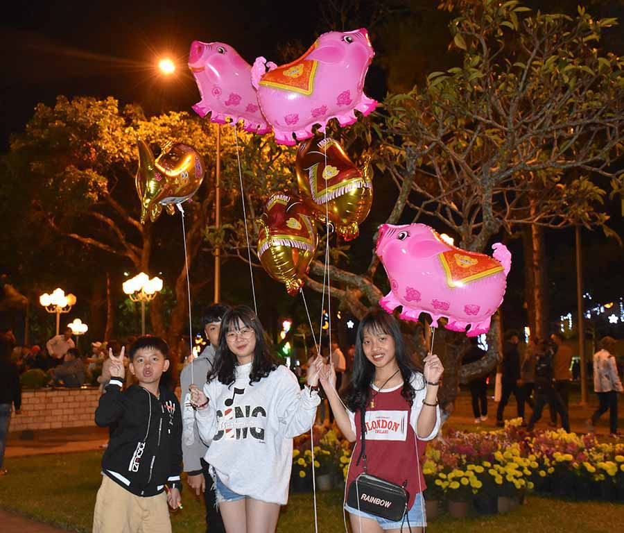 Nhiều bạn trẻ hứng thú với các loại bóng bay hình con heo. Ảnh Trần Dung