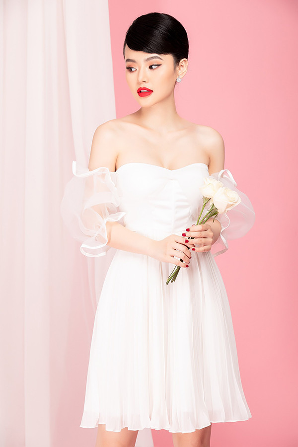 Đầm quây ngực khoe vai trần gợi cảm được trang trí thêm phần tay voan mỏng manh. Sắc trắng cùng cách kết hợp chất liệu sẽ mang tới bộ cánh hợp không khí xuân phương Nam.