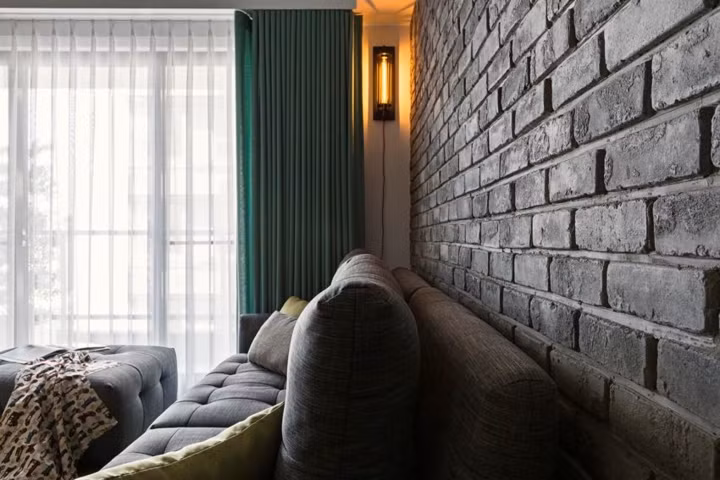 Chiếc đèn treo cổ điển làm sáng bức tường gạch màu xám.