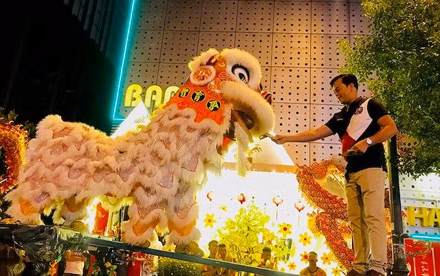  Người xem tặng quà tiền, con lân múa theo nhịp trống và từ từ tiến lại ngậm 