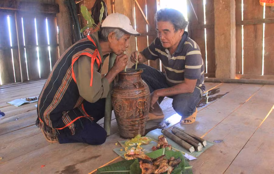 Sau nghi lễ cúng thần linh thì mọi người quây quần bên nhau thưởng thức rượu ghè, cơm lam, thịt nướng. Ảnh: Chí Hào