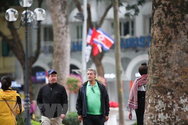 Quốc kỳ ba nước Việt Nam, Mỹ và Triều Tiên cùng cái bắt tay tượng trưng cho hòa bình hữu nghị xuất hiện rất nhiều tại khu vực trung tâm thành phố Hà Nội. (Ảnh: Trọng Đạt/TTXVN)