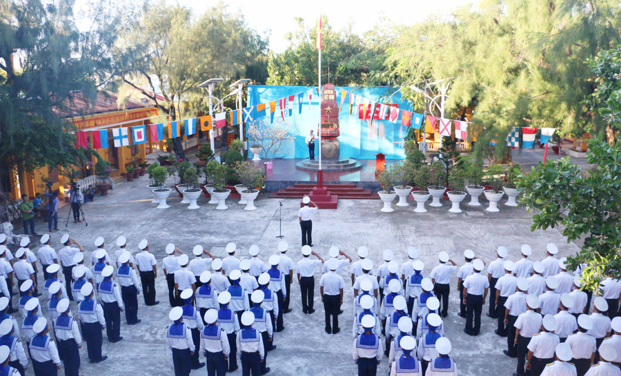 Các bộ, chiến sĩ và nhân dân đảo Sinh Tồn thực hiện nghi lễ chào cờ đầu năm mới. Ảnh: Quang Tấn
