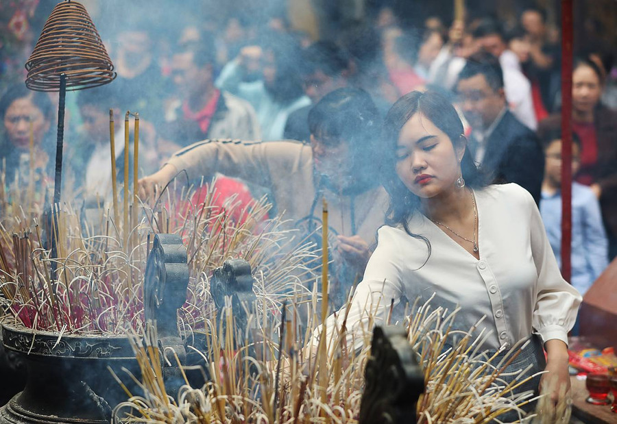  Chiếc lư hương lớn đặt giữa sân chùa Quán Sứ kín đặc chân nhang của người dân đến lễ.