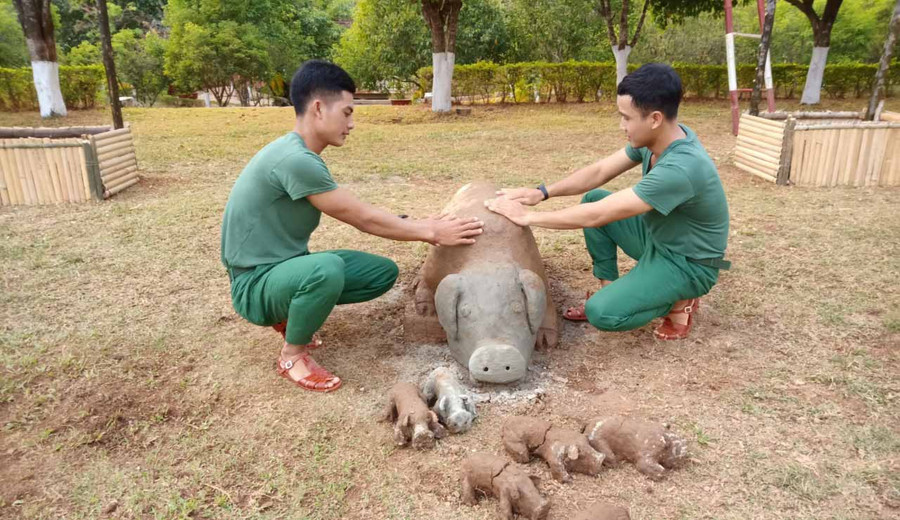 Các chiến sĩ bên đàn heo bằng đất sét. Ảnh: Phương Dung