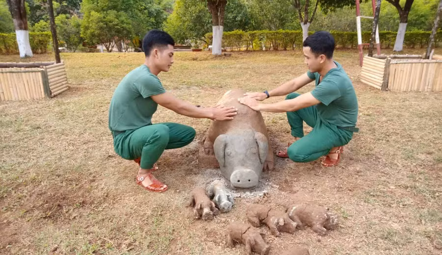 Các chiến sĩ bên đàn heo bằng đất sét. Ảnh: Phương Dung