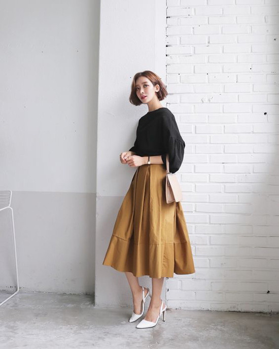 Chân váy midi dáng xòe, áo blouse là cặp bài trùng luôn tạo nên hình ảnh điệu đà và thanh nhã cho chị em công sở.