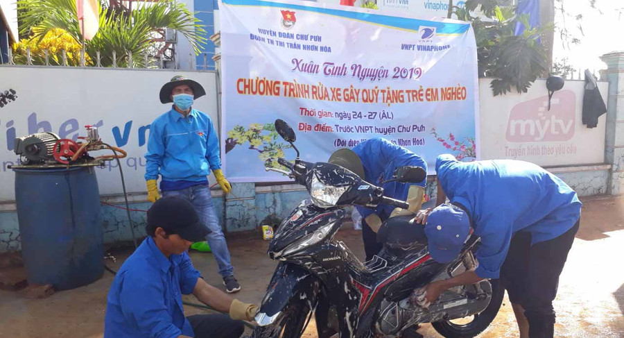 Đoàn thanh niên thị trấn Nhơn Hòa rửa xe gây quỹ tặng trẻ e nghèo. Ảnh: Lê Trang
