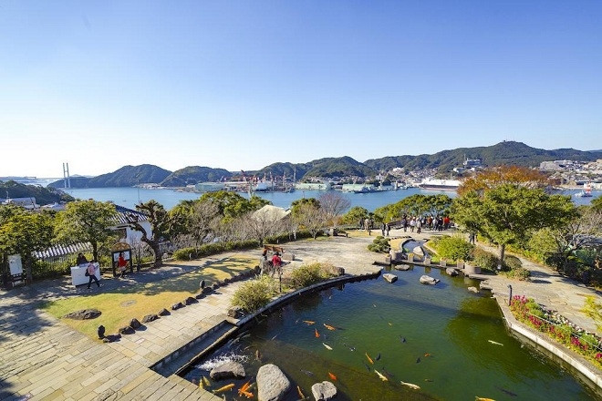  Từ lan can toà nhà Former Mitsubishi No.2 Dock House trong không gian vườn Glover cũng là một điểm ngắm toàn cảnh Nagasaki với núi đồi trập trùng, thuyền tàu neo đậu trên cảng. Vườn Glover còn có căn nhà của thương gia Thomas Blake Glover (Scotland) được xây từ 160 năm trước. Đây được cho là nơi đem đến cảm hứng để nhà soạn nhạc Puccini viết nên vở opera huyền thoại “Madame Butterfly”