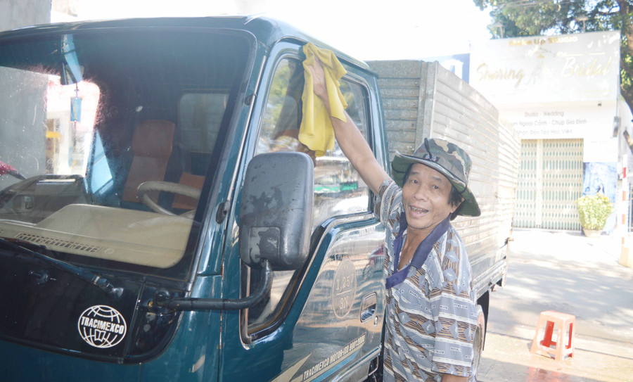 Ông Nguyễn Văn Khâm cười tươi đón nhiều khách đến rửa xe. Ảnh: Đinh Yến 