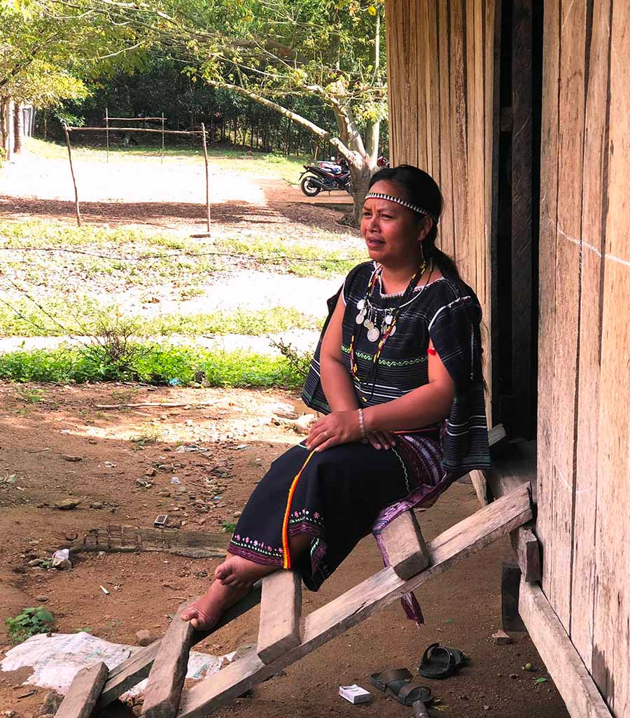  Chị Đinh Thị Lơnh ngồi hát dân ca bên bậc cửa. Ảnh: Hồng Thương