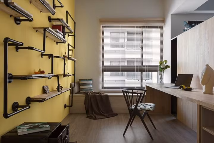 Sau kệ tivi là khu vực làm việc, giá sách làm từ đường ống dẫn nước sáng tạo.