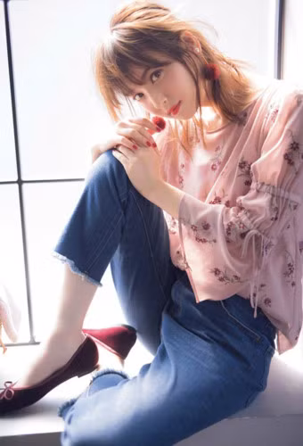  Người đẹp 29 tuổi diện quần jeans và áo hoa, đeo bông tai cùng tông màu son môi, sơn móng tay.