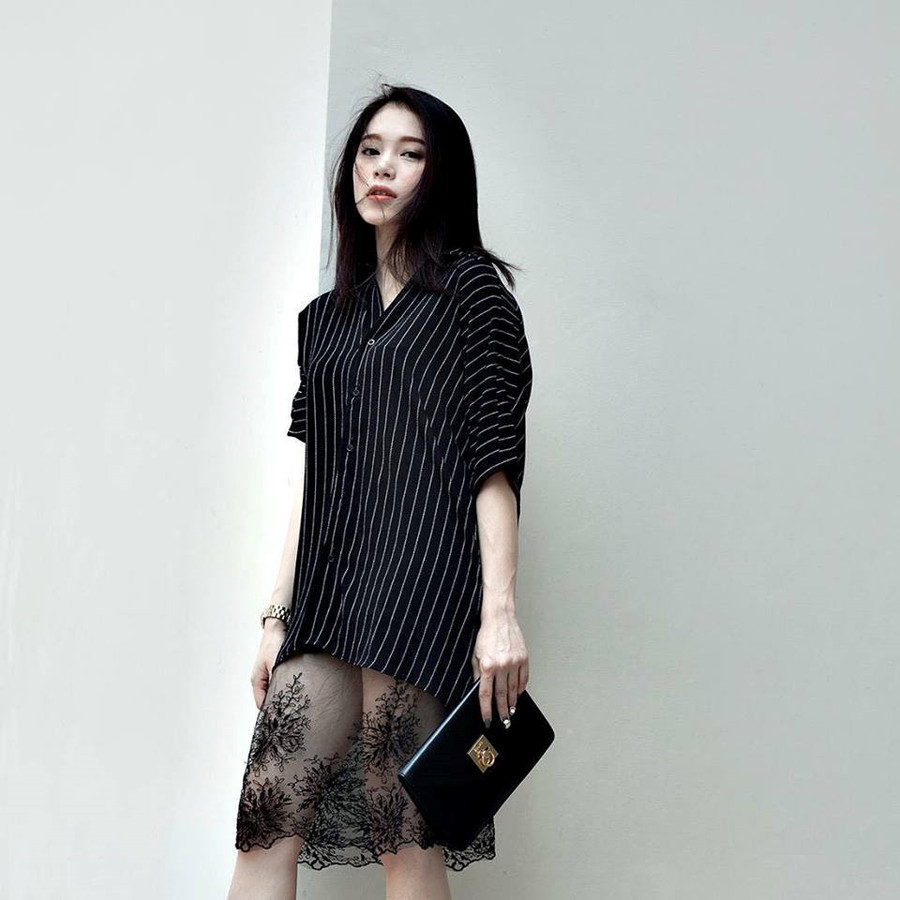 Ngô Phương Linh chia sẻ bí quyết thể hiện hình ảnh một tiểu thư gợi cảm, sành điệu khi kết hợp phá cách chiếc áo sơ mi kẻ sọc phom dáng dài, cùng chân váy ren xuyên thấu và túi xách cầm tay đơn giản.