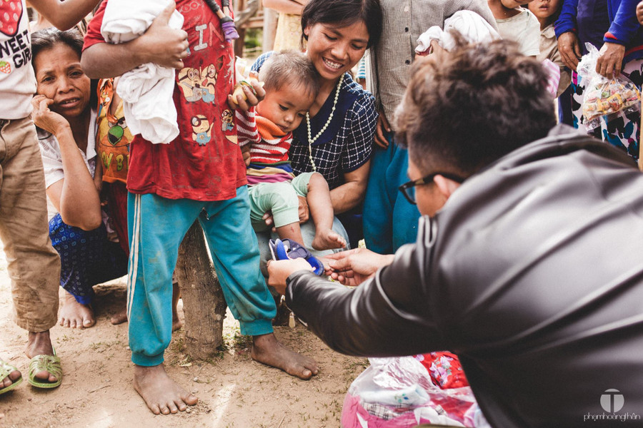 Mẹ ẵm con thử dép mới nào - Ảnh: P.H.T