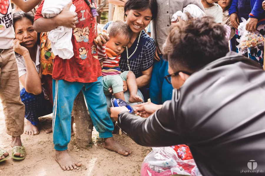 Mẹ ẵm con thử dép mới nào - Ảnh: P.H.T