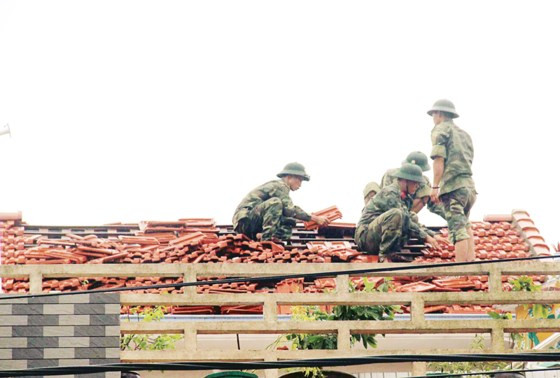 Bộ đội giúp dân lợp lại mái nhà bị gió bão số 10 đánh tốc mái.